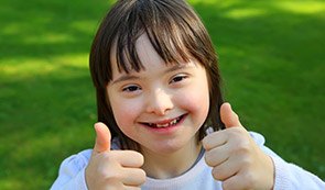 Little girl outdoors giving thumbs up