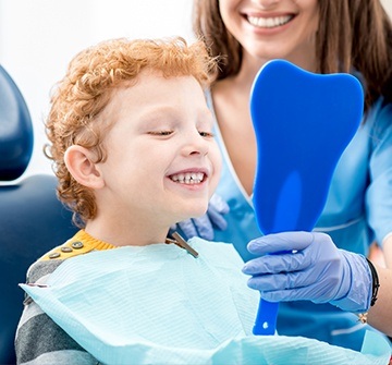 Little boy in dental chair looking at his smile