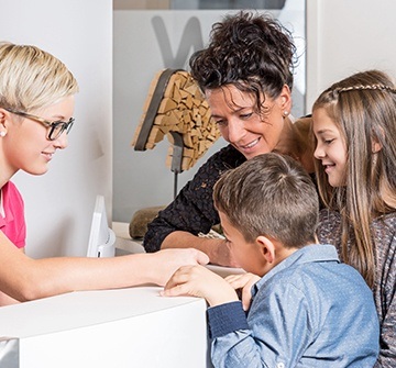 Mother and children at dental reception desk