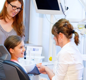 mother and daughter talking to dentist
