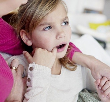 Child picking object out of teeth