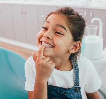 a child pointing to her tooth