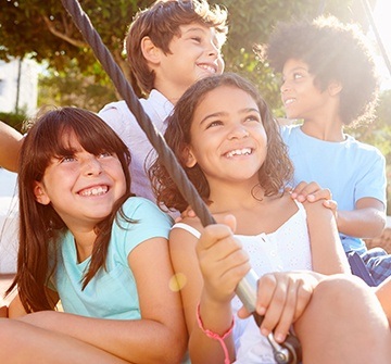 Four kids smiling together outdoors