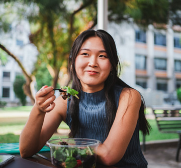Teen girl smiling while eating outside