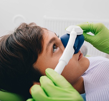 Dentist placing nose piece over child's nose