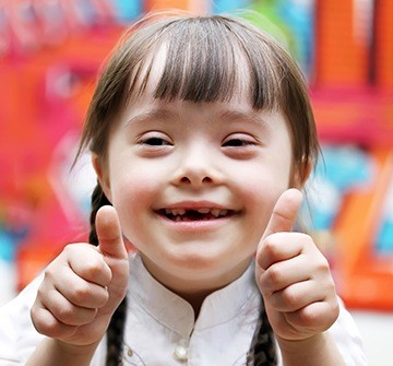 Little girl smiling and giving thumbs up