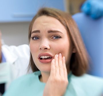 Woman holding her cheek in pain