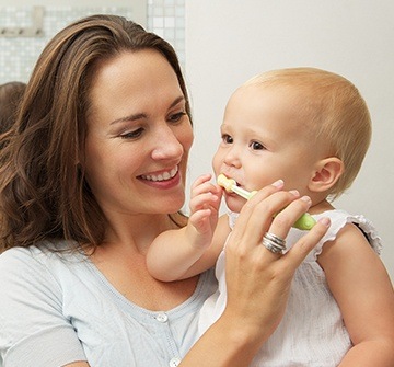 Mother brushing child's teeth