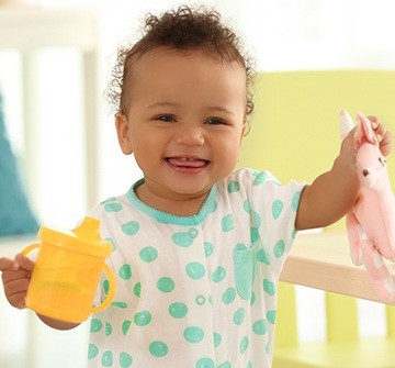 Little girl holding sippy cup