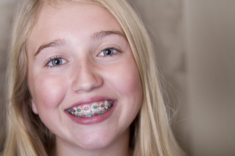 A young child wearing multi-colored braces.