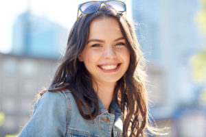 Teenage girl smiling after Invisalign treatment