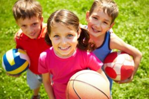 Children with sports balls smiles after visiting New Britain emergency dentist