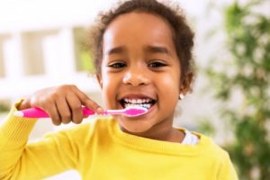 Young girl brushes teeth after visiting New Britain children's dentist