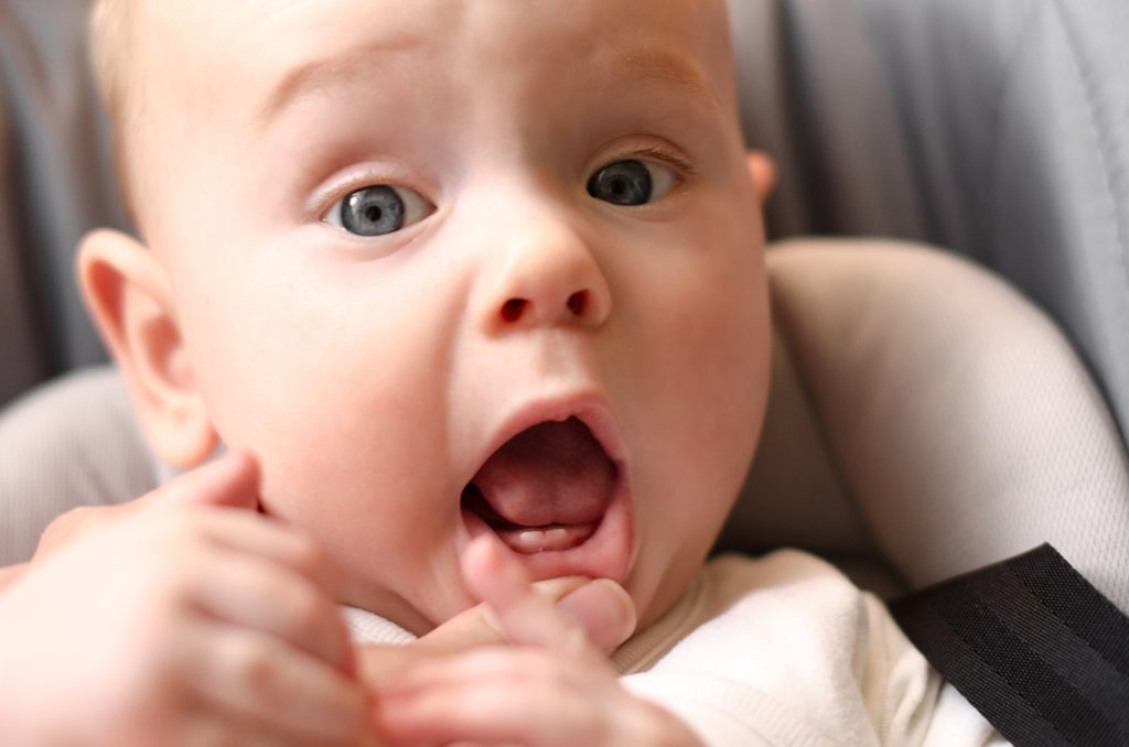 Closeup of baby’s tongue and two front teeth