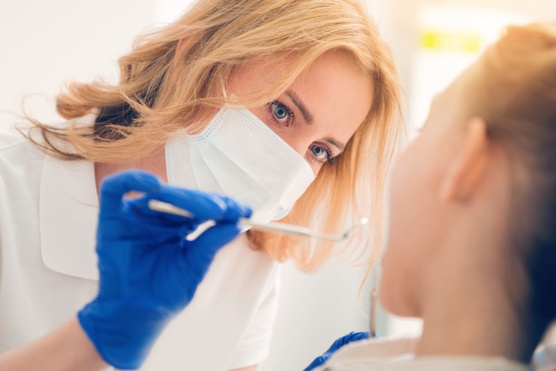 Closeup of dentist looking inside child's mouth