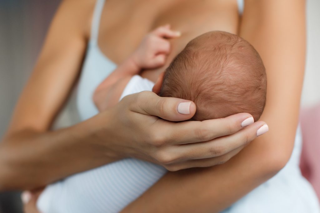 Closeup of parent holding a nursing baby