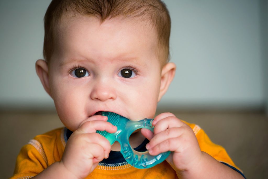 Closeup of baby chewing on teething ring