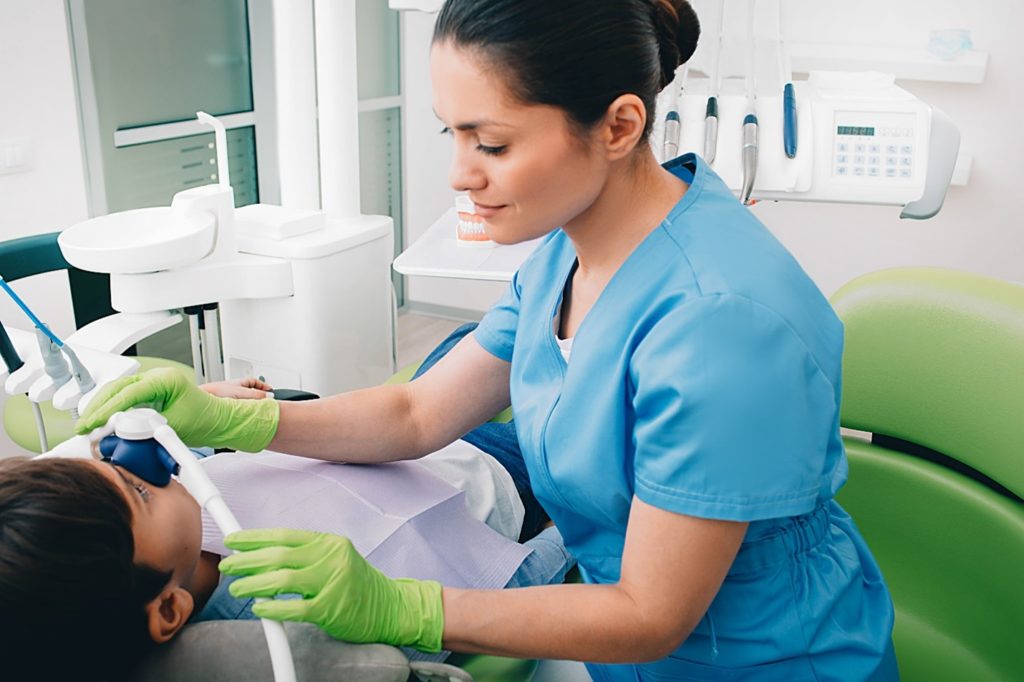 Dentist placing nasal mask over patient's nose