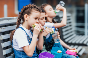 a group of schoolchildren eating lunch